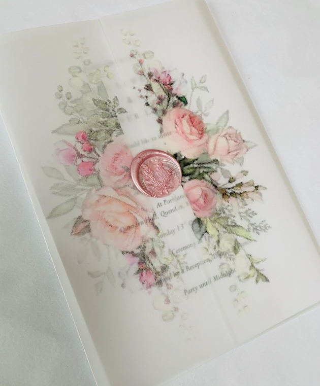 Handcrafted wedding stationery on white with floral decorations
