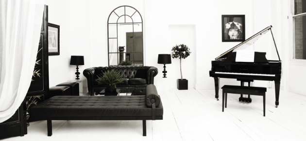 Black furniture and piano in a white room