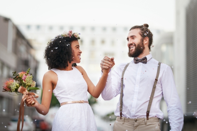 Couple hold hands in urban location