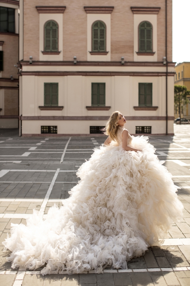 Bride running through the street in a large flamboyant dress