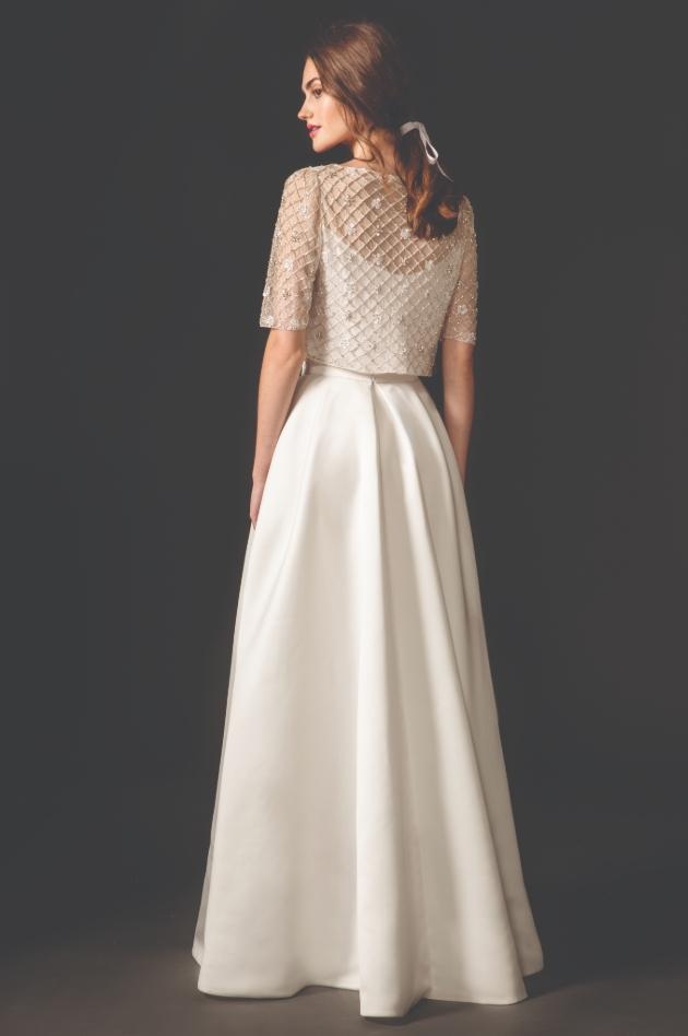 Model is wearing wedding dress with jacket-style overlay