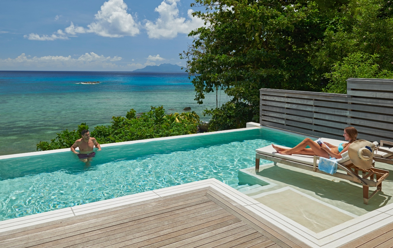 couple in pool looking out to ocean