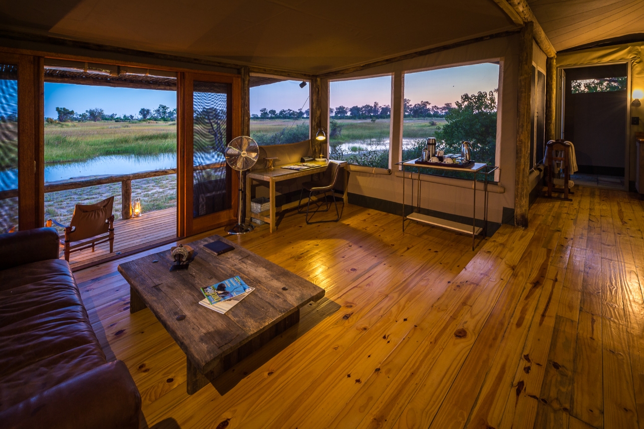 inside a lodge on bushland looking out at a creek