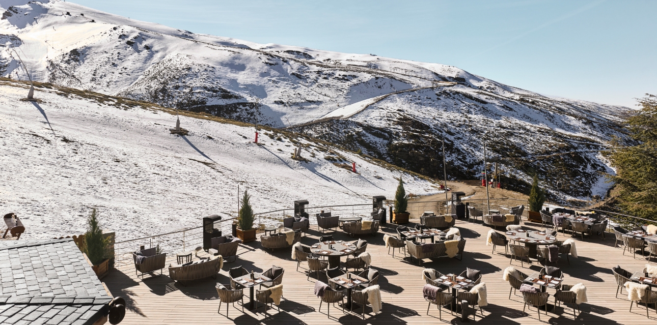 El Lodge chairs on a terrace with slopes in the background