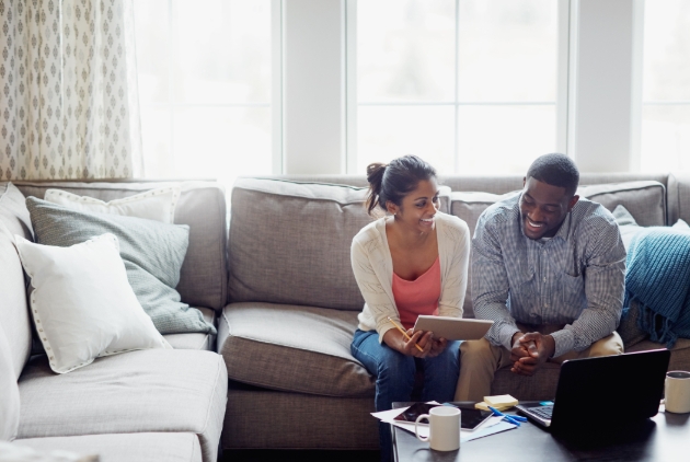 couple on sofa looking at paperwork