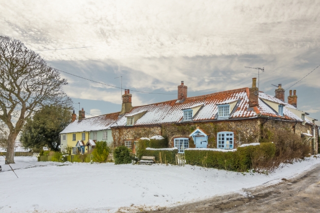 terraced cottage, brick house blue door covered in snow