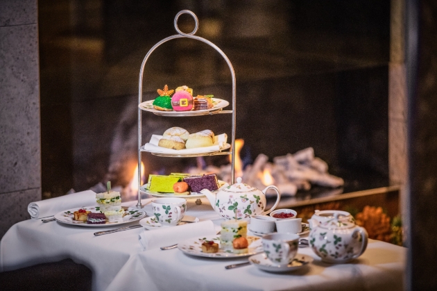 table with an afternoon tea set up on it with fire in the background