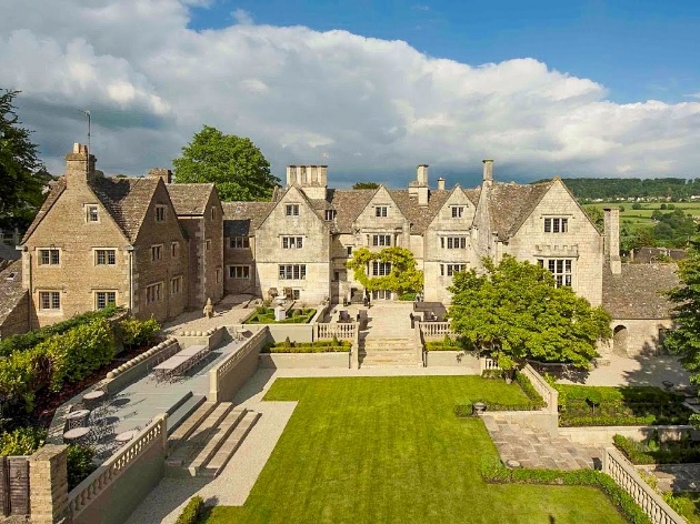 grey brick manor with lawns and views