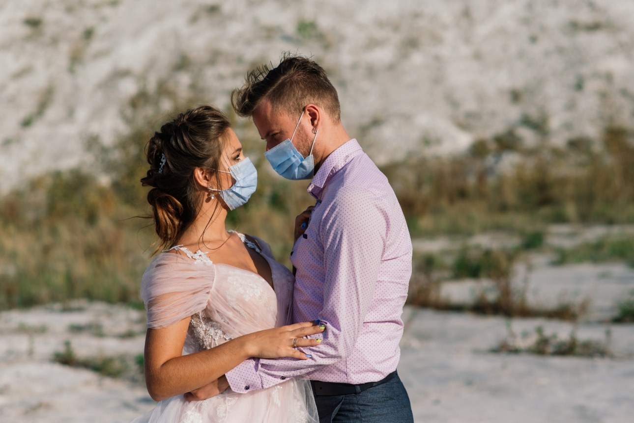 couple in masks in wedding gear