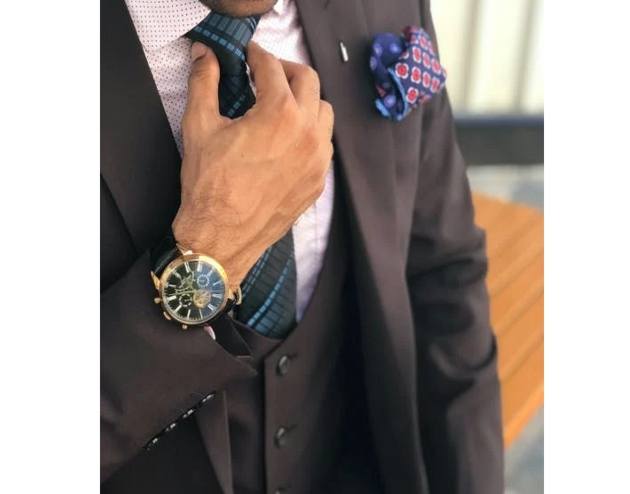 man in plain suit jacket and checked tie