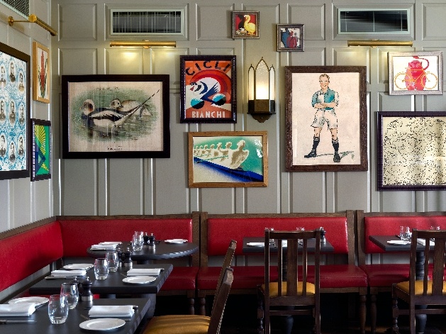 tables and chairs with unusual artwork on the walls 
