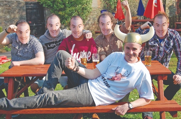 group of men on a bench in mask and one in a viking hat