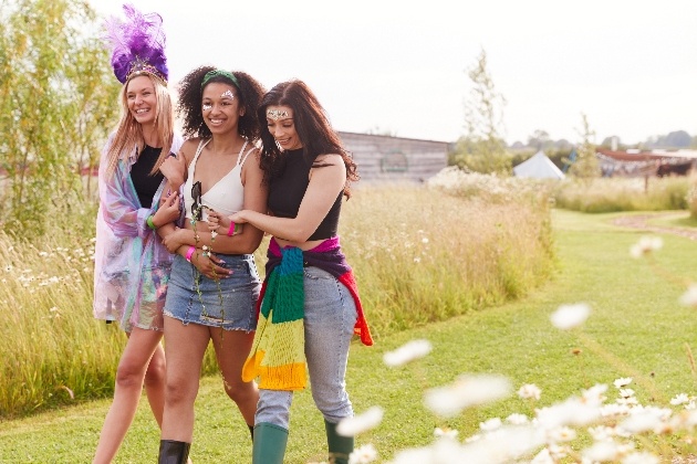  women in party gear walking near teepee