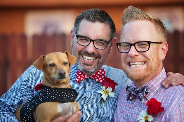 couple in formal wear with pet dog in their arms