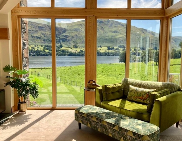 sofa in front of large window looking out to hills
