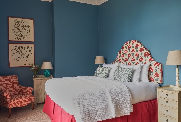 blue room with bed and chitzy decor