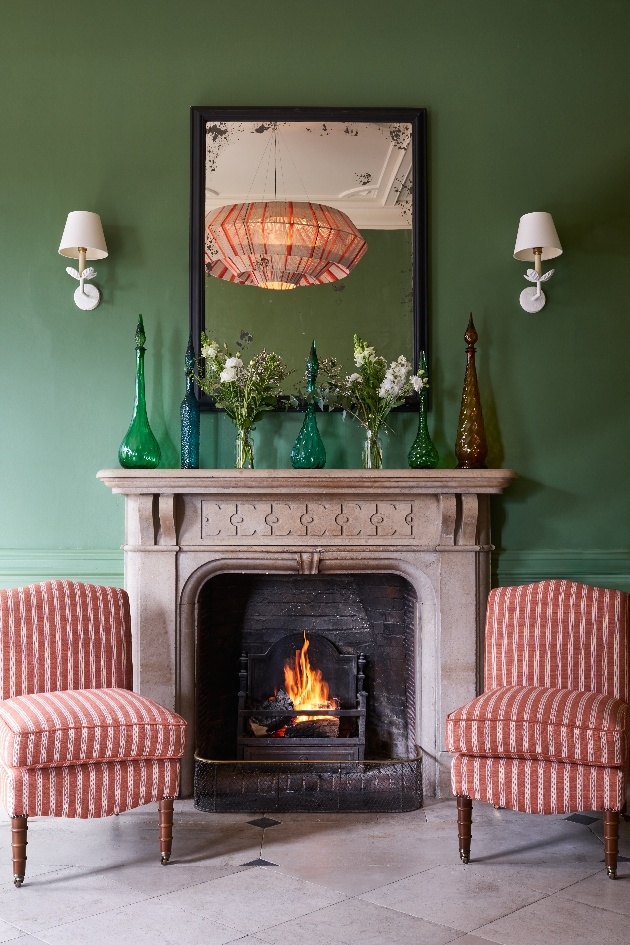 green wall fireplace two armchairs