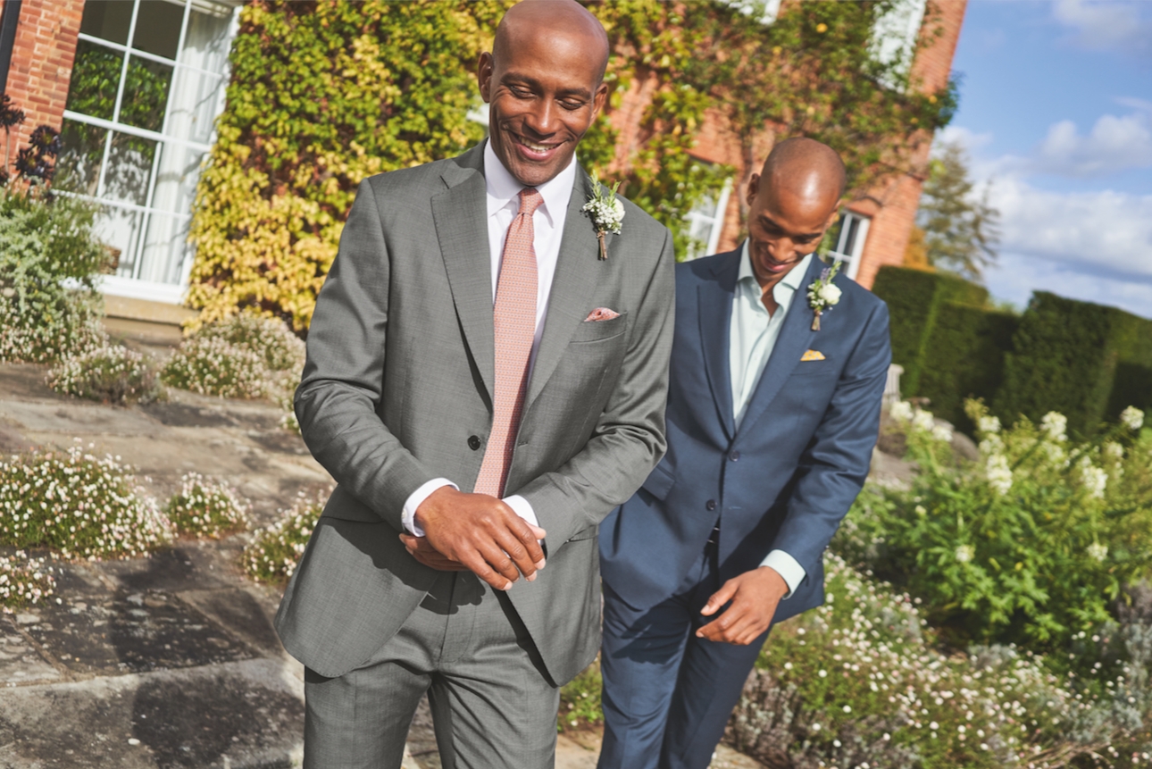 two men in suits one grey and one blue suit