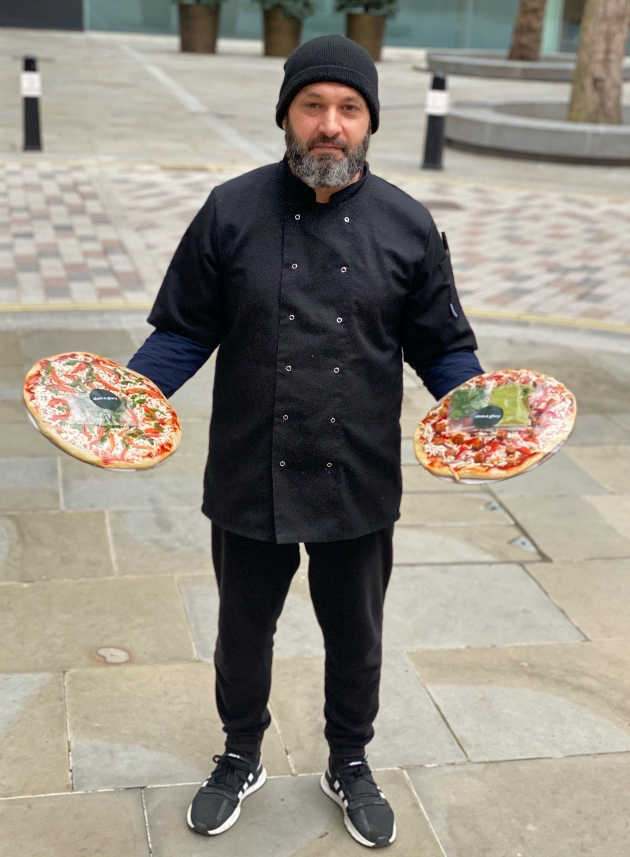 Chef holding pizza in each hand