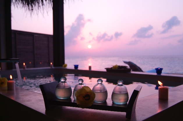 oil bottles next to hot tub at night with ocean view