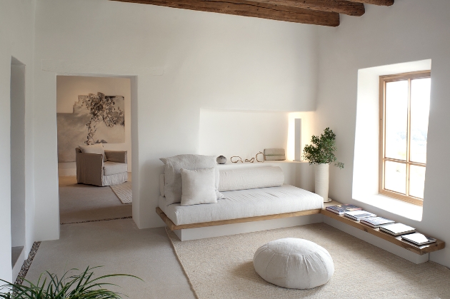 white lounge with white sofa and decor, roof has wooden beams exposed