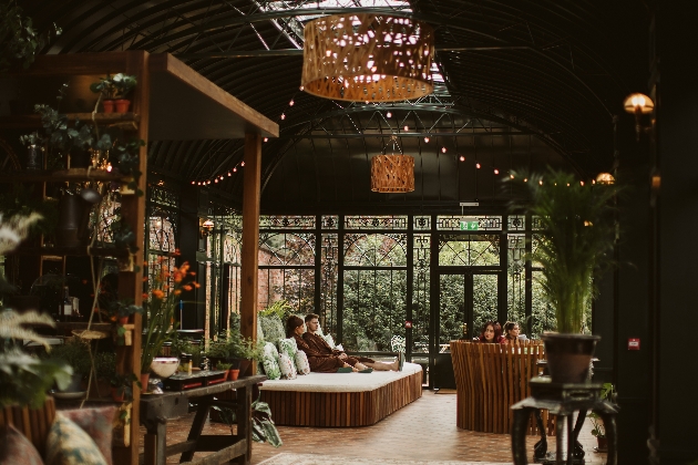 inside the spa palm house with day beds, loads of plants, high ceiling and people laying around in robes