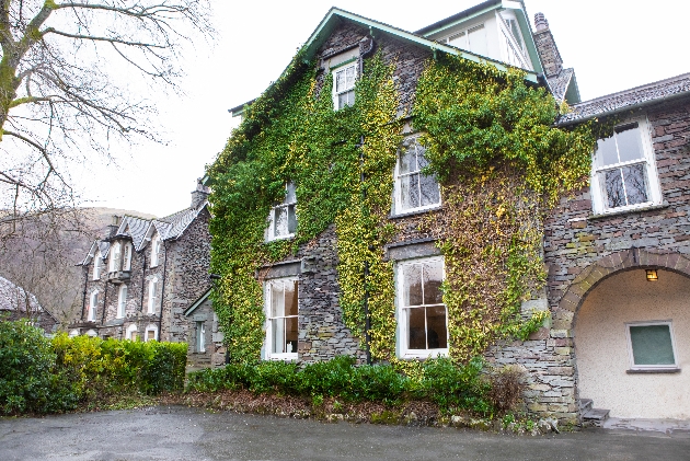 front of hotel grey brick and covered in ivy