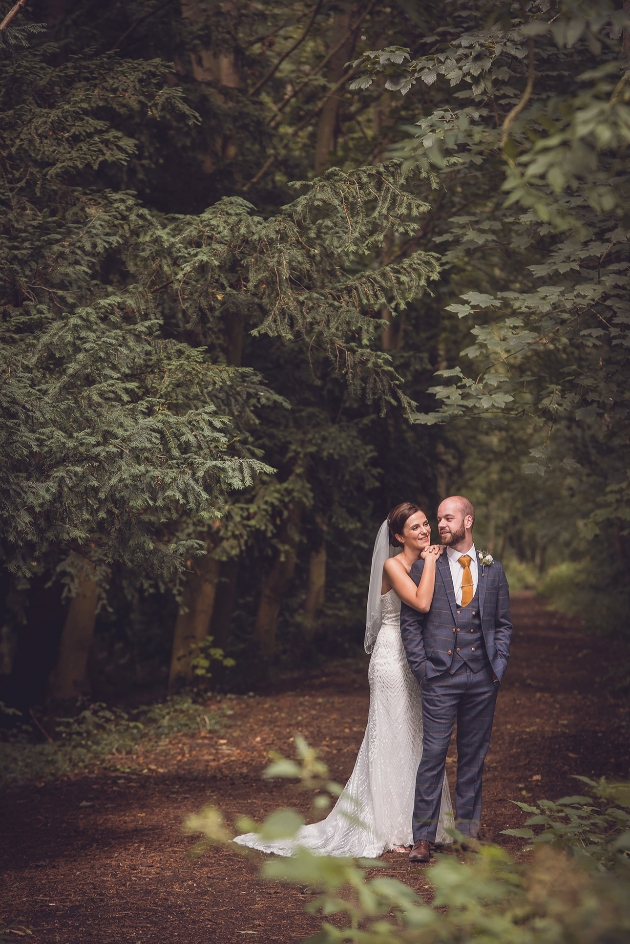 Bride and groom pose in woodland