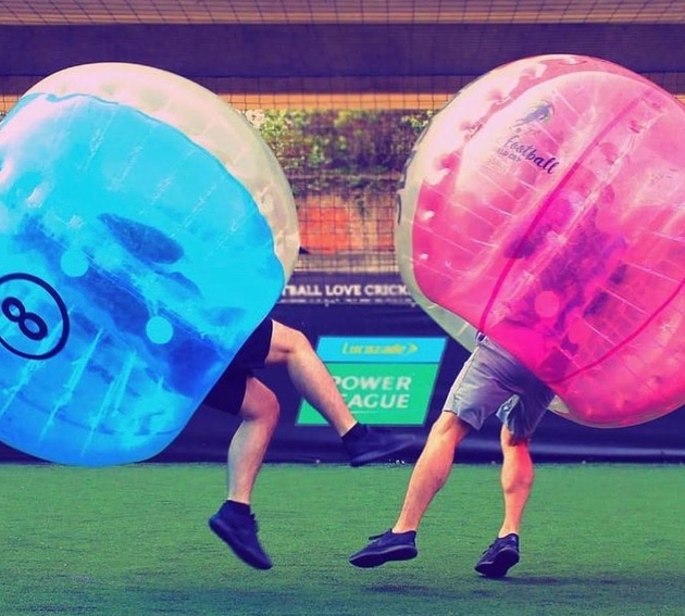 two men crashing in to each other wearing giant bubbles