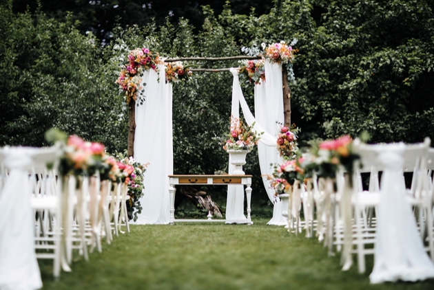 outdoor ceremony set up with floral backdrop