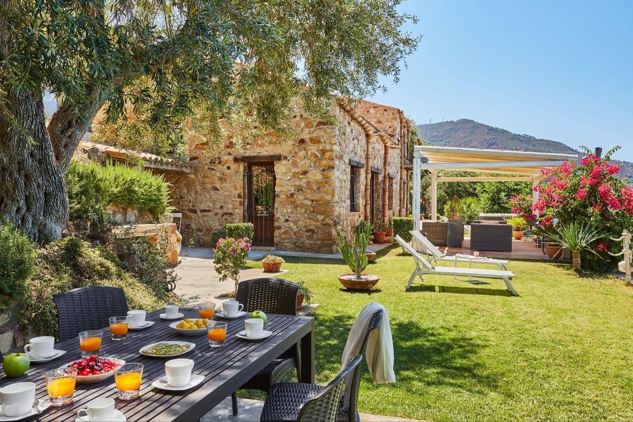 garden of stone villa with deckchairs