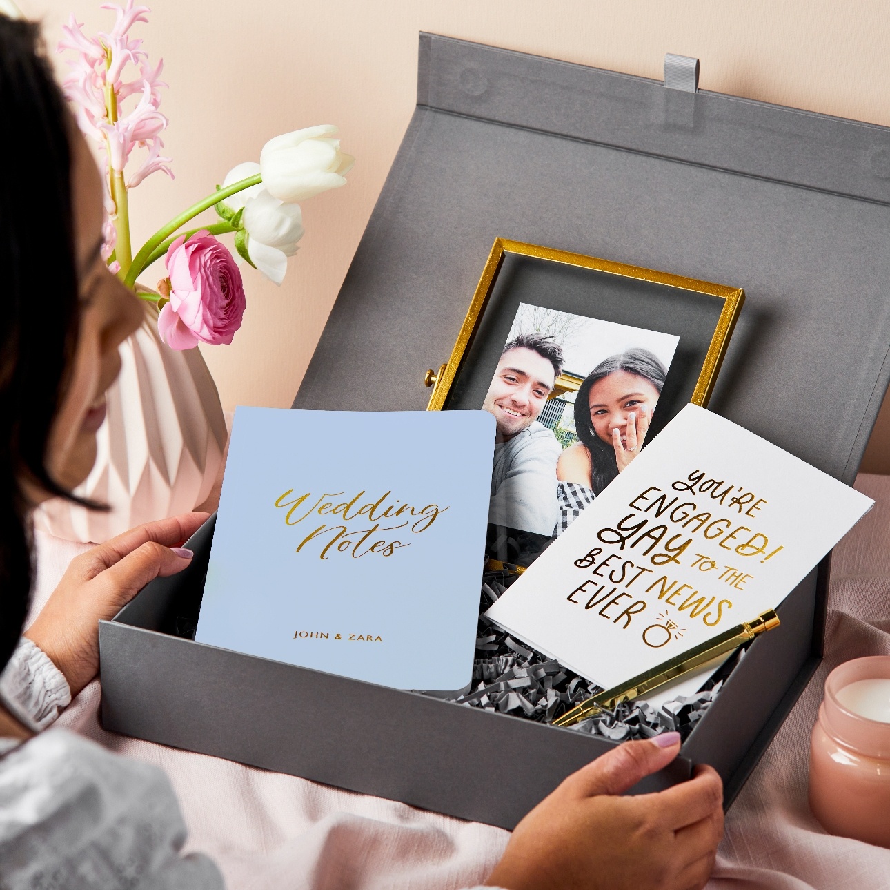 a black gift box with photo frame, two note pads and gold pen
