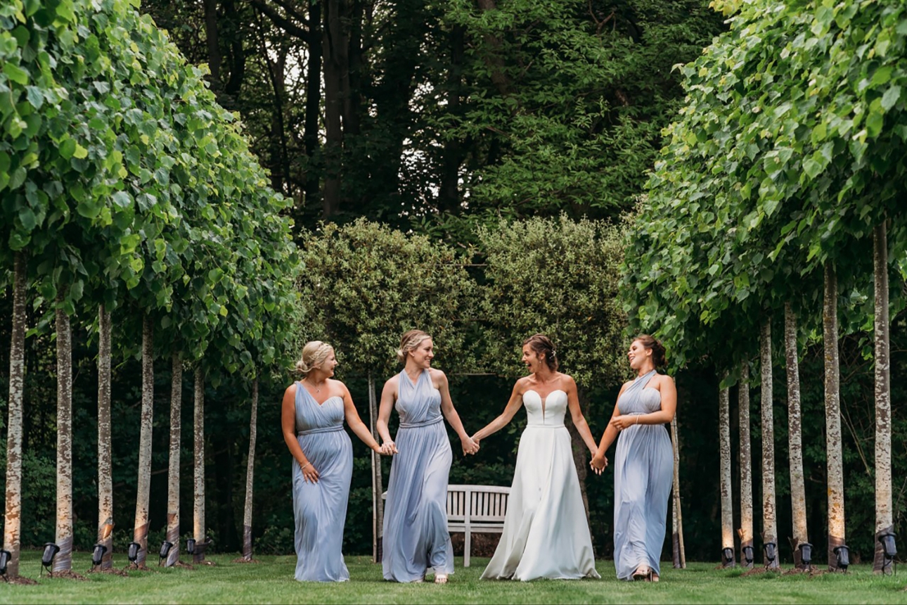 Bride and bridesmaids laughing in garden