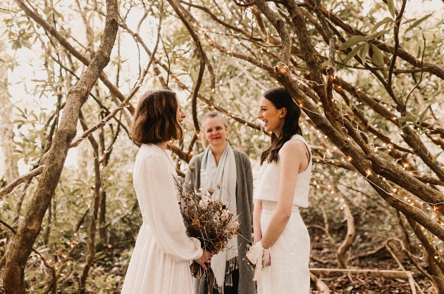 two bride getting married in the woods with a celebrant