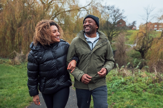 man and woman walking arm and arm outside