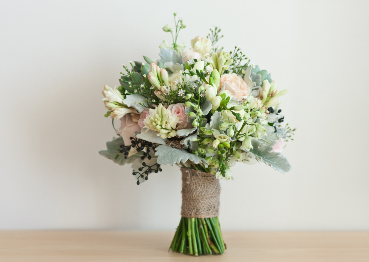 bouquet of wedding flowers tied with hessian on a table