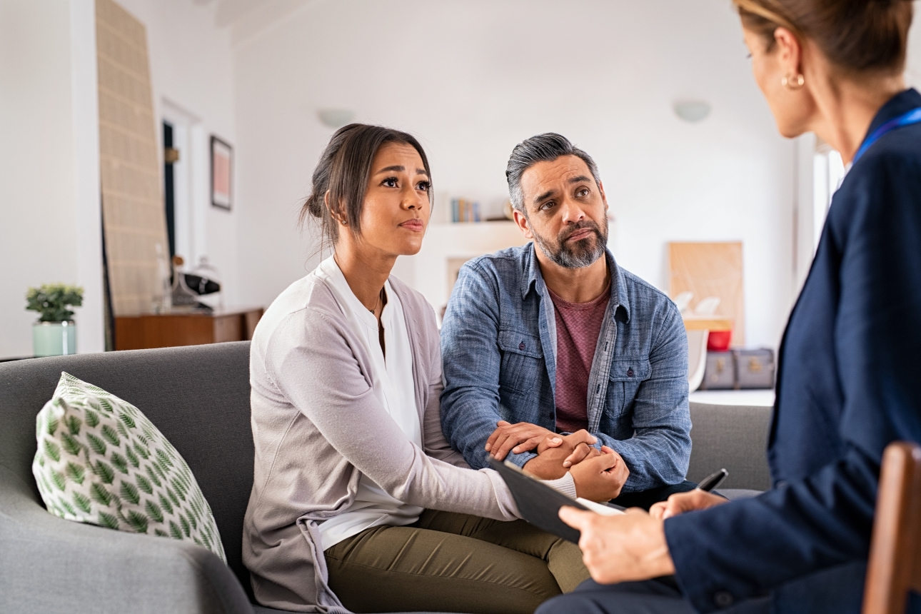 couple sitting on sofa talking to a solicitor