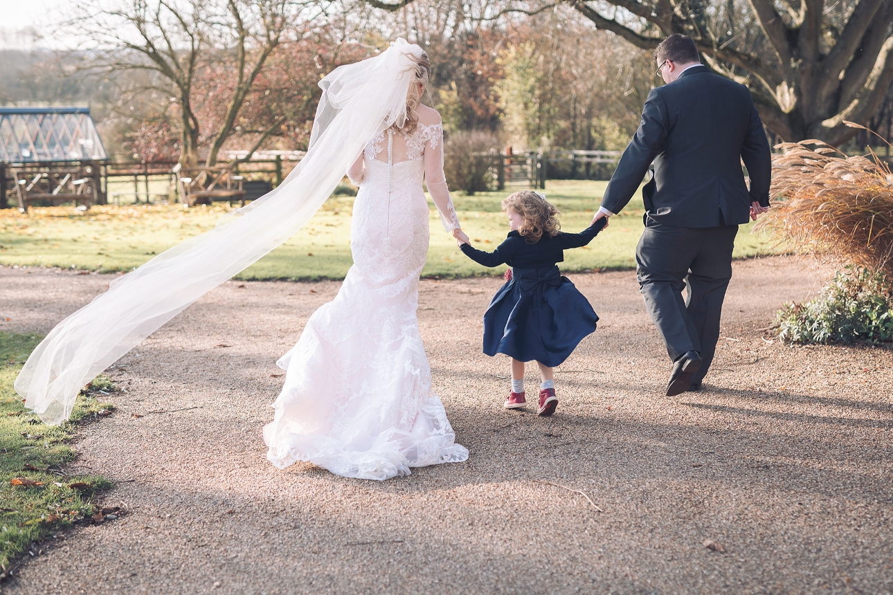 Bride and groom holding child's hand