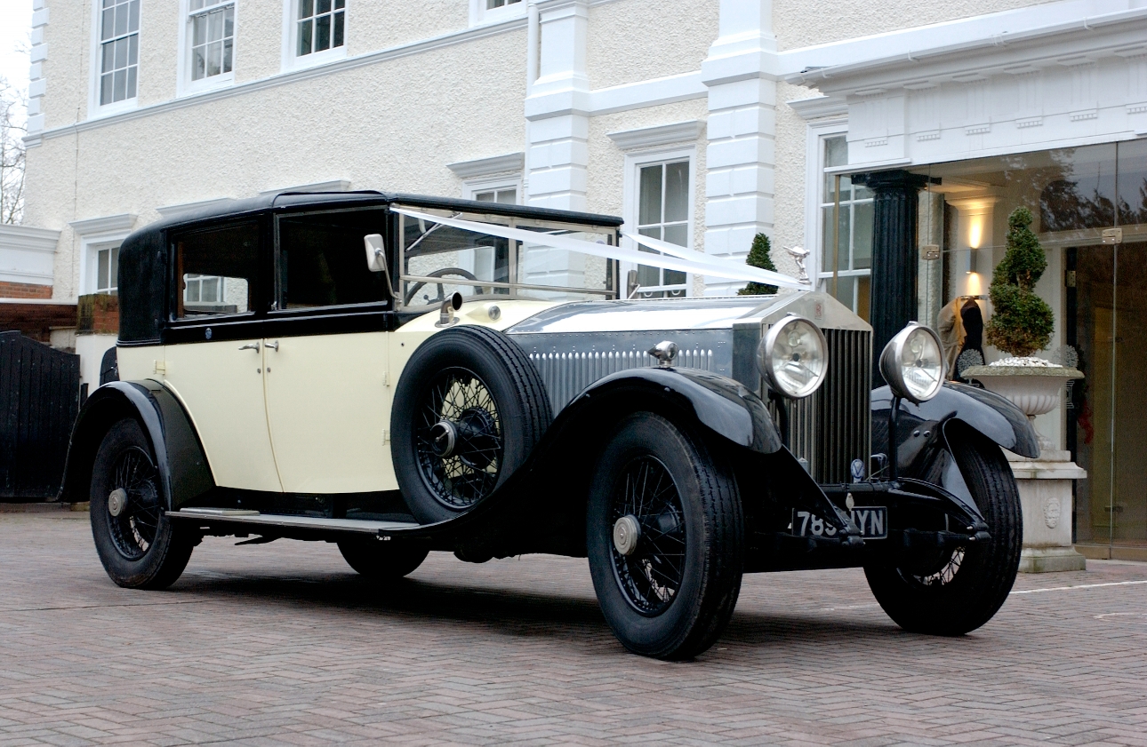 black and cream vintage classic car outside manor house