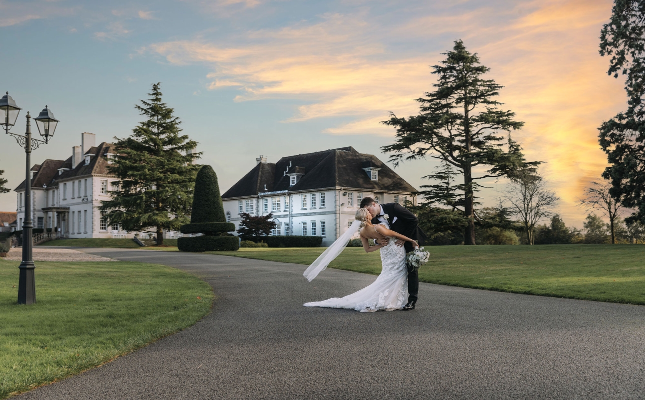 Bride and groom kiss in front of sunset