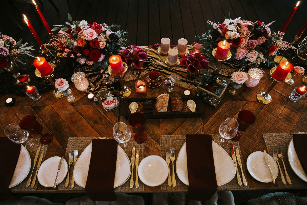 Winter tablescape red flowers, berry napkins, gold cutlery