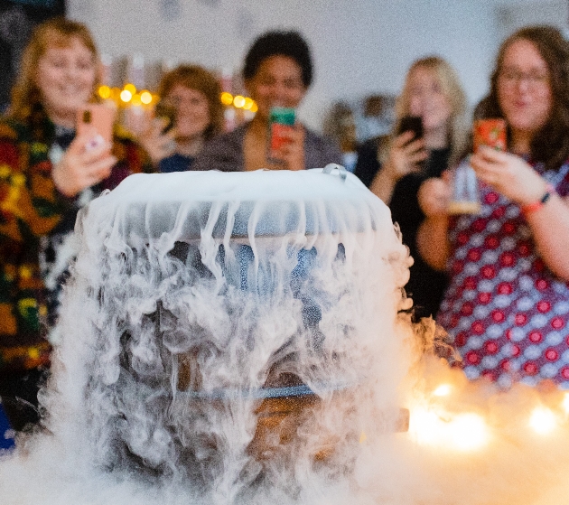 smoking cauldron with people gathered round