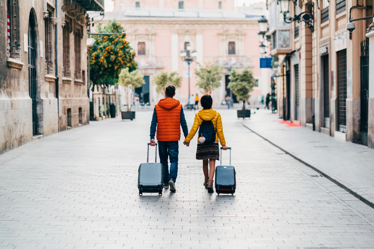 couple with their luggage bags in streets of rome
