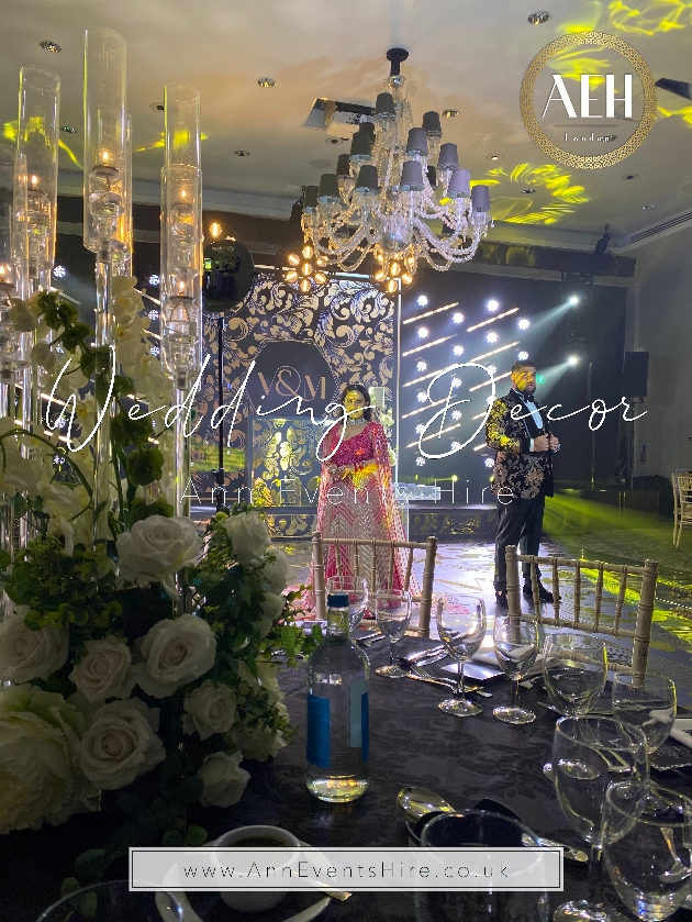 table set up with chandelier candle in vases on tables 