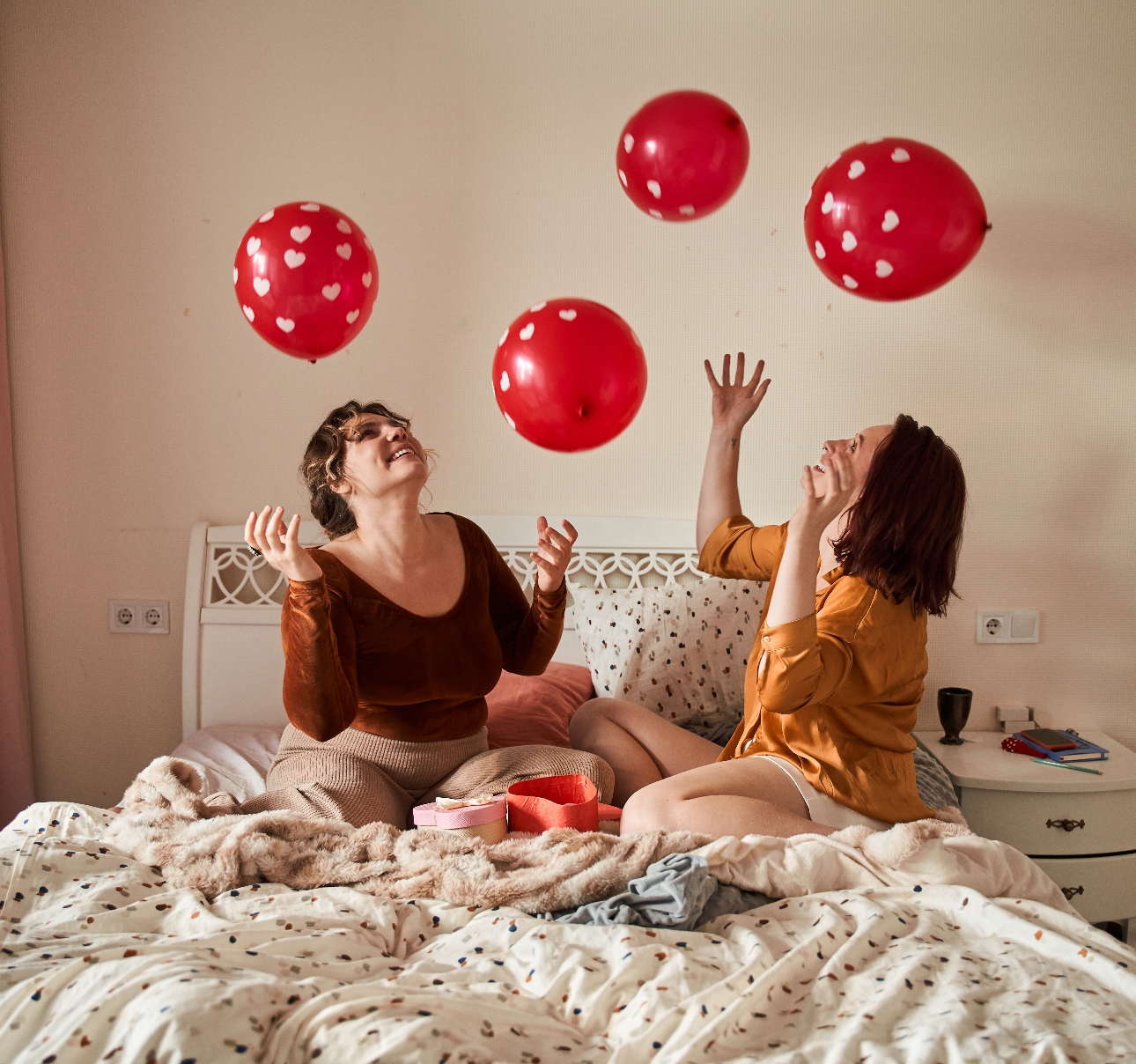 two women on a bed celebrating valentine's day