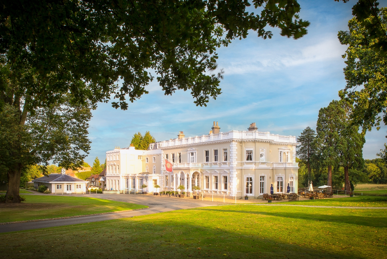 Burhill Golf Club cream and white georgian building with lots of trees and grounds