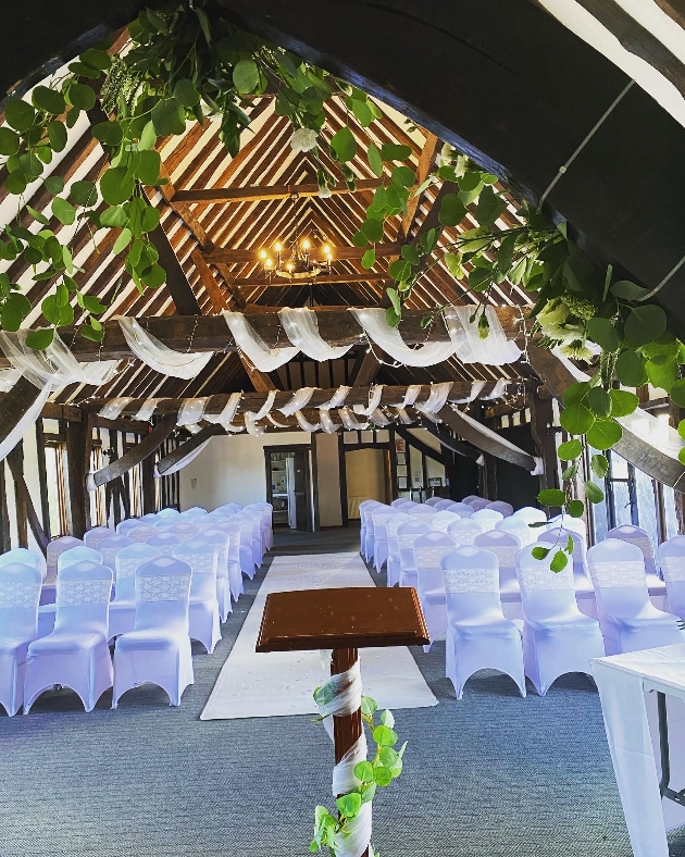 ceremony set up white chair covers drapes hanging from ceiling