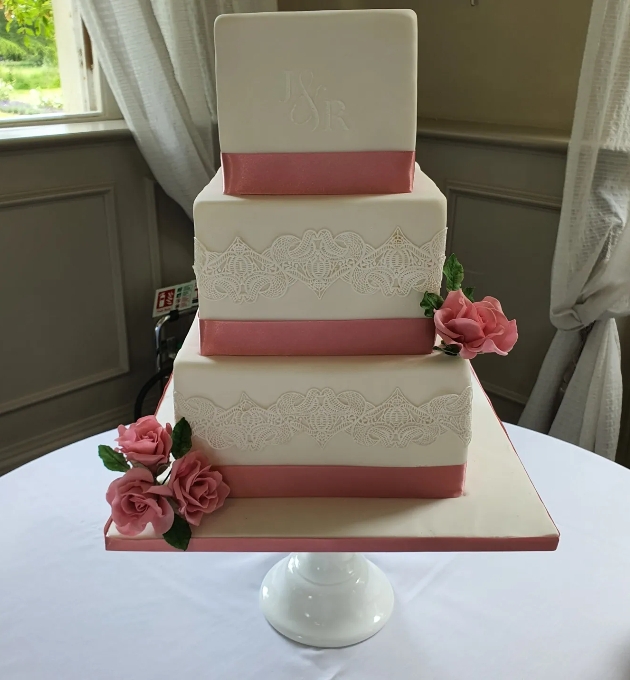 two tier buttercream wedding cake topped with flowers