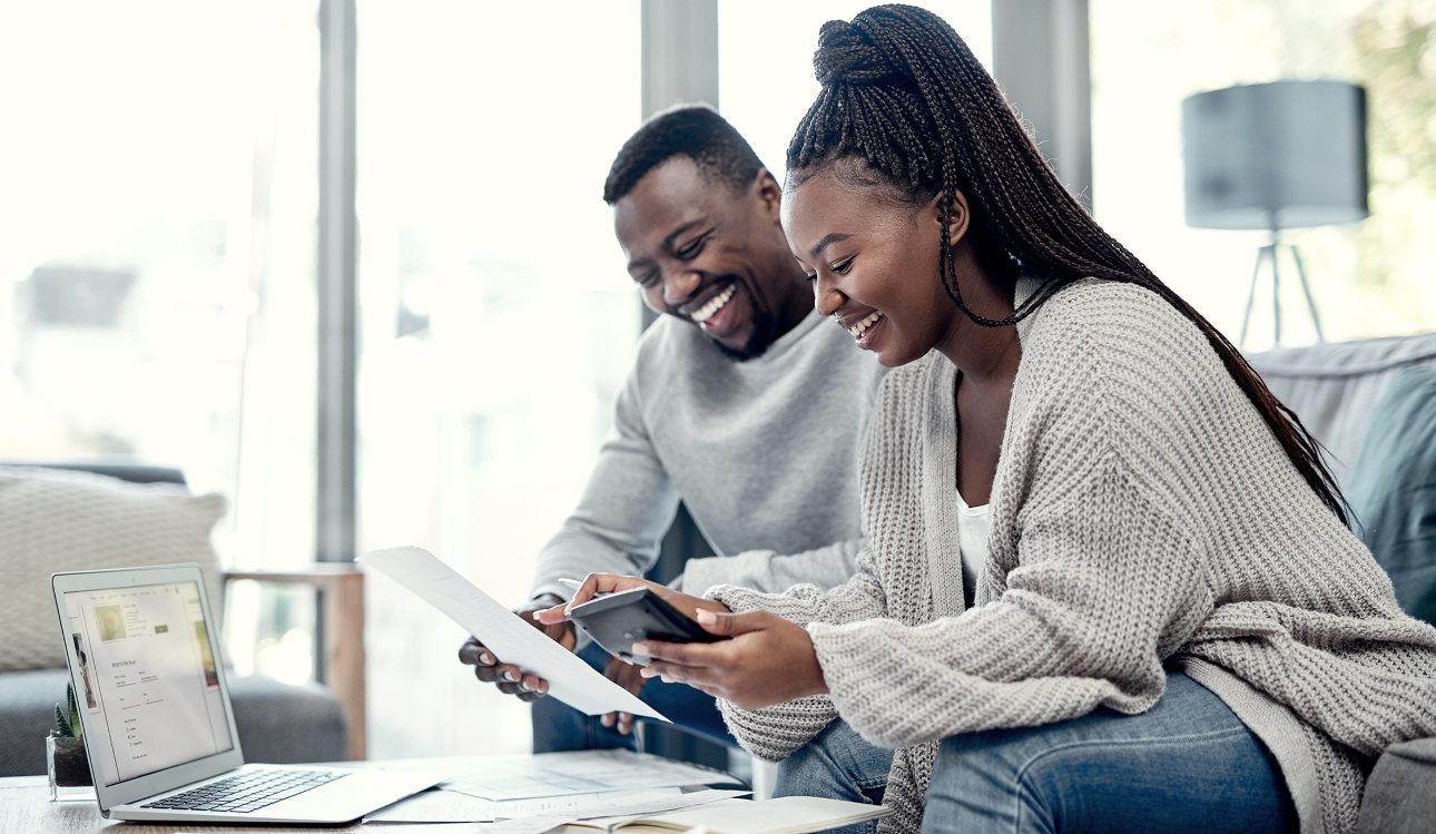 couple at table with lap top high fiving