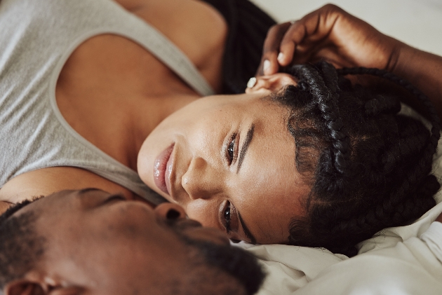 couple laying on bed looking at eachother